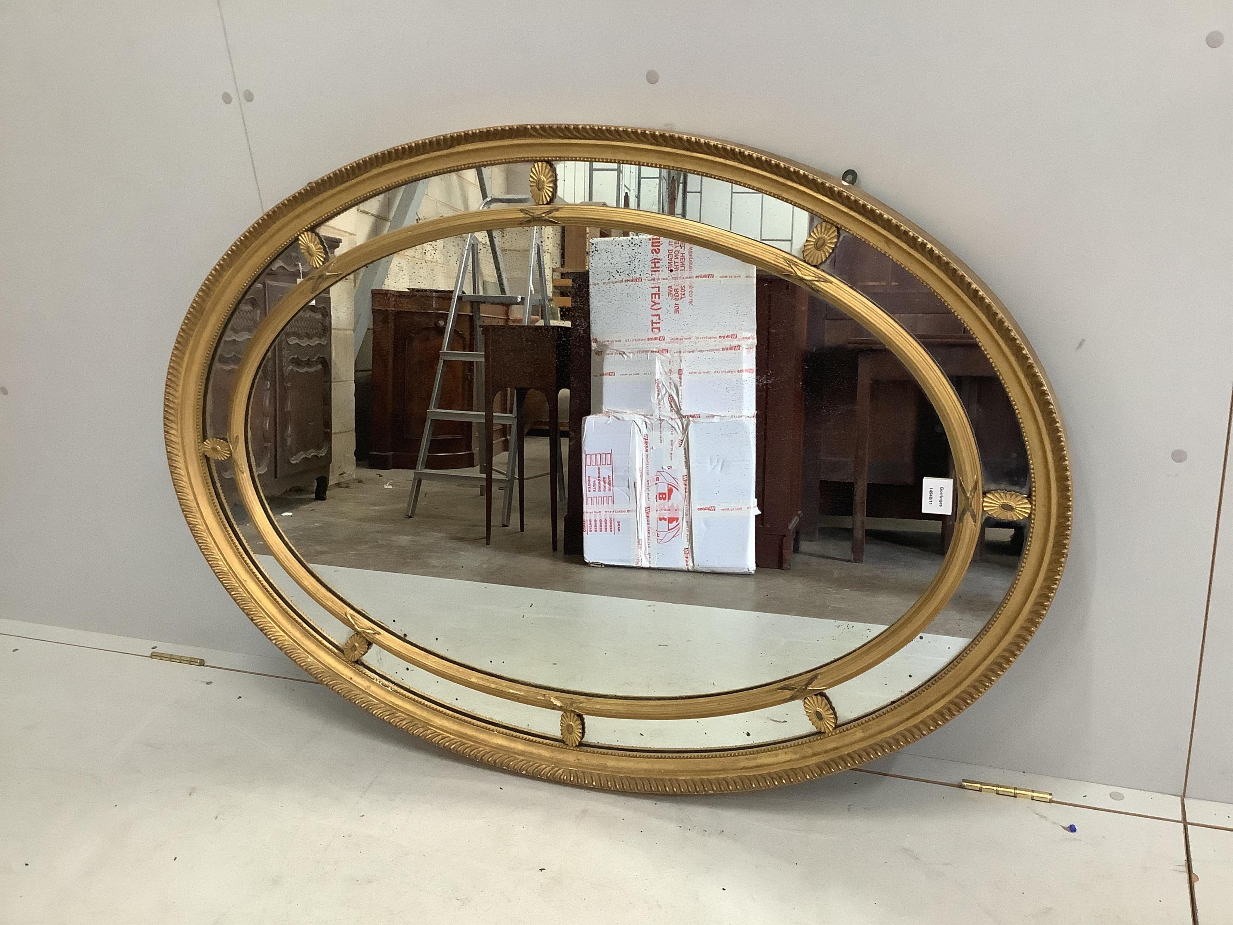 A Sheraton style oval marginal plate wall mirror, width 85cm, height 124cm. Condition - good